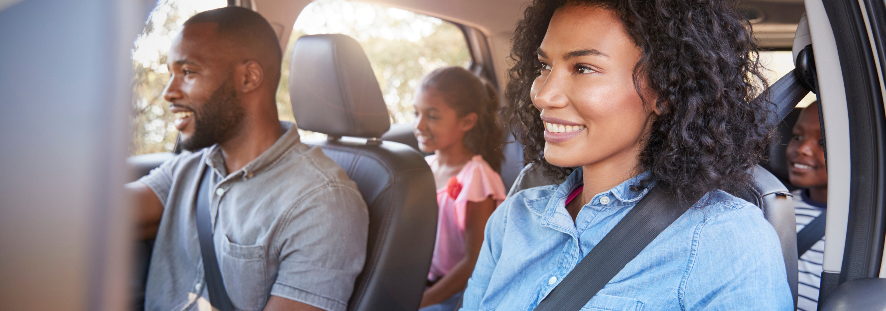 Family in a car looking happy and engaged, all facing forward and showing no signs of motion sickness.