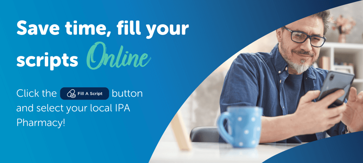 Man with glasses looking on his phone in his home on a laptop - MOBILE VERSION